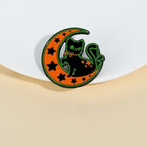 Détail d'un pin's d'Halloween en émail avec un chat noir sur un croissant orange