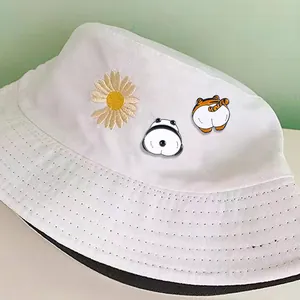 Daisy bucket hat with cute cartoon panda and tiger enamel pins on white canvas fabric