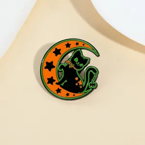 Détail d'un pin's d'Halloween chat noir assis sur un croissant de lune orange émaillé
