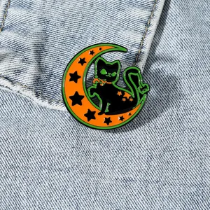 Broche d'Halloween avec chat noir et croissant de lune orange sur veste en jean bleu
