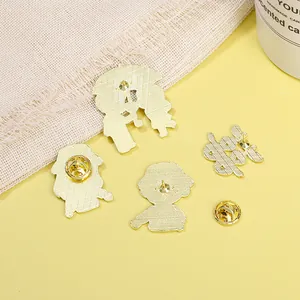 Golden enamel brooches back view with metal butterfly clasps and grid texture
