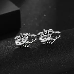 Macro shot of silver stag beetle cufflinks with polished finish on black background