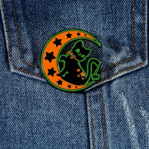 Détail d'une broche Halloween chat noir et lune orange sur une veste en jean