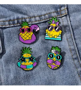 Détail de quatre épingles en émail ananas mignonnes sur denim avec motifs de plage d'été