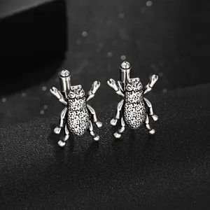 Macro view of vintage silver beetle cufflinks with detailed oxidized metal texture