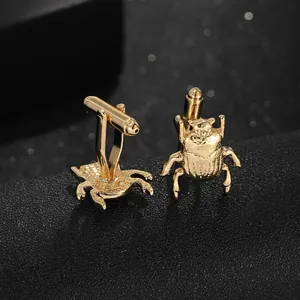 Macro detail of golden beetle cufflinks featuring intricate texture and standard T-bar backings