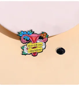 Detailierte Emaille-Brosche mit floraler Gebärmutter und Slogan auf rosa Hintergrund