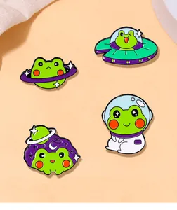 Nahaufnahme von vier niedlichen Astronauten-Frosch-Emaille-Pins mit Weltraumthemen