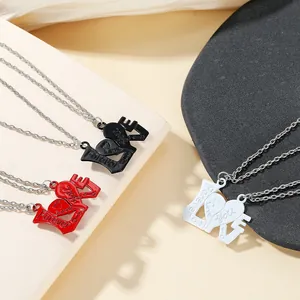 Detail of LOVE puzzle necklaces for couples in black, red, and white on a textured backdrop