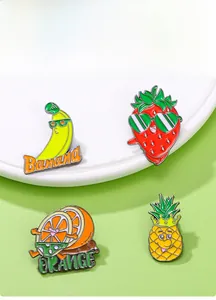 Détails de quatre broches en émail aux fruits, banane et orange, sur fond vert pastel