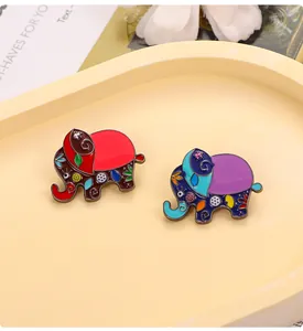 Détail macro de broches éléphants en émail bohème avec des motifs floraux