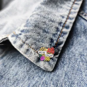 Emaille-Brosche Rippenbogen mit Blumen und Inhale Peace Exhale Chaos auf Jeansjacke