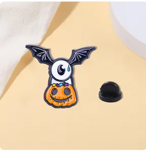 Detalle macro de un pin esmaltado de Halloween con ala de murciélago, ojo y calabaza