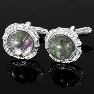 Macro shot of silver round cufflinks with purple-green stone and crystal border