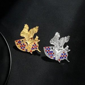 Macro detail of eagle brooches featuring red and blue rhinestones on metallic finishes