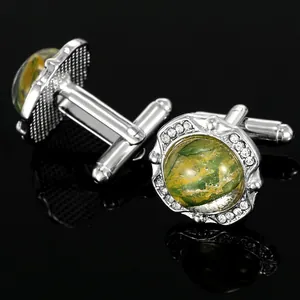 Detailed macro view of silver polished cufflinks with green marble stone and zircon inlay