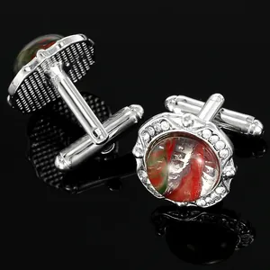 Silver round cufflinks with marble glass texture and crystal halo on black reflective background