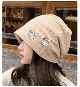 Detailed close-up of beige knitted hat with Happy Easter bunny embroidery decoration