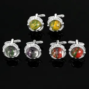 Detailed view of silver cufflinks with colorful swirl patterns and sparkling crystal halo