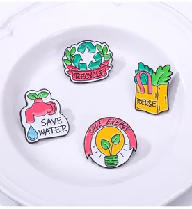 Détail de quatre épingles en émail éco-responsables avec slogans de recyclage sur un plat