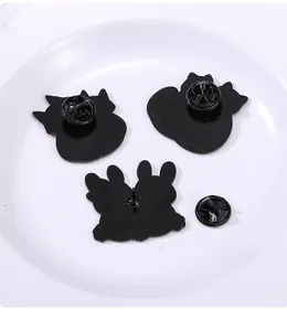 Dettaglio del retro delle spille smaltate con chiusure a farfalla in metallo su ceramica