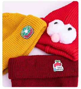 Trois bonnets en tricot assortis avec écussons écologiques et yeux de monstre