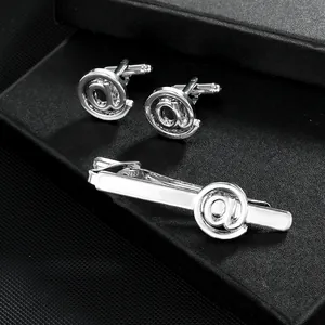Elegantes Set aus Krawattenklammer und Manschettenknöpfen mit @-Symbol in schwarzer Box