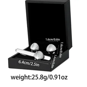 Detailansicht der muschelförmigen silbernen Manschettenknöpfe und Krawattennadel im Set