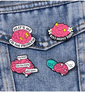Détail de quatre épingles en émail sur la santé mentale fixées sur du tissu denim