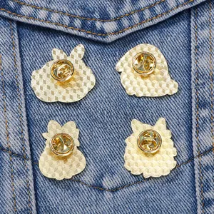 Set of four cute rabbit enamel pins with secure butterfly clutches on denim fabric