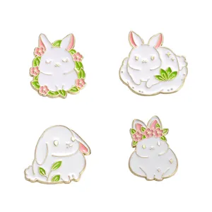 Set of four cute white rabbit enamel pins with floral details in gold plated alloy