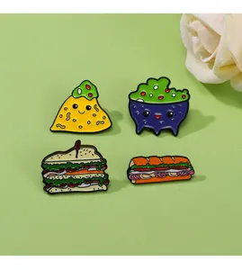 Set of four colorful enamel food pins featuring a taco, dip, sandwich, and sub sandwich