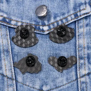 Vue arrière de quatre badges en métal noir avec texture en nid d'abeille sur denim