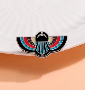 Macro detail of Egyptian winged scarab enamel brooch with silver plating and rich colors