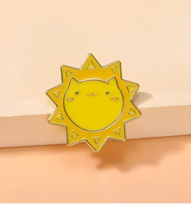 Détail d'un pin's émaillé chat soleil mignon en jaune sur un socle géométrique rose