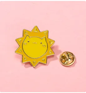Vue macro d'un pin's en émail soleil chat créatif avec un fermoir papillon doré