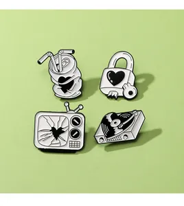 Close-up of four retro enamel pins including a TV and vinyl record on green background