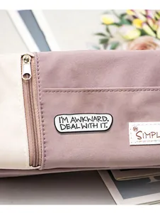 Detailansicht der Emaille-Anstecknadel auf Canvas-Tasche mit Fokus auf Stoffstruktur