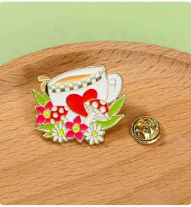 Détail du pin's émaillé tasse de thé avec champignon et cœur sur plateau bois