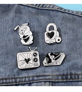 Black and white enamel pins set on denim fabric featuring retro vinyl and TV designs
