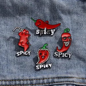 Set of four red chili enamel brooches with spicy lettering on blue denim fabric