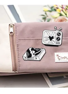 Detail of vintage TV and record player enamel pins on a purple and white canvas bag