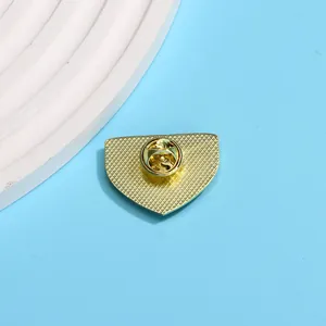 Dos de la broche dorée en métal triangulaire avec texture antidérapante et fermoir papillon