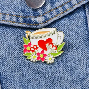 Broche en émail tasse à thé avec cœur et champignon sur veste en jean