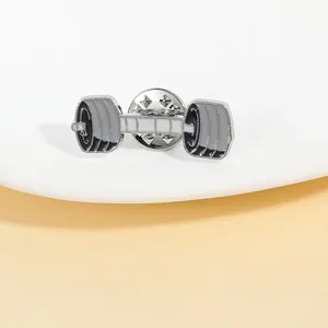 Macro detail of dumbbell shaped enamel pin showing black and white enamel finish