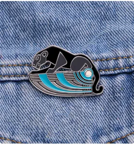 Detail of an Egyptian leopard enamel pin with blue geometric base on denim fabric