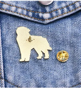 Detail of a sheepdog alloy brooch back with butterfly clasp on blue denim fabric