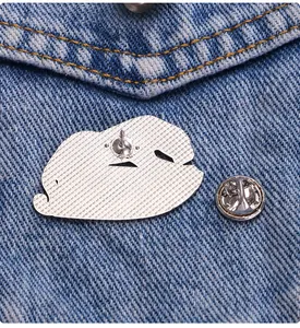 Detailed back view of a metal leopard brooch with butterfly clutch on denim fabric