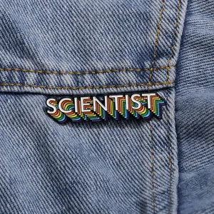 Kreative Emaille-Brosche mit SCIENTIST-Schriftzug und Regenbogen-Schatten auf Denim