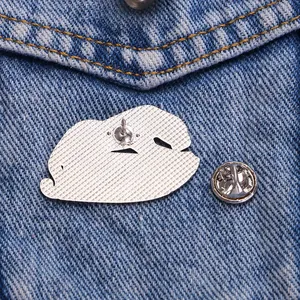 Silver alloy leopard brooch with textured back and butterfly clasp on denim fabric